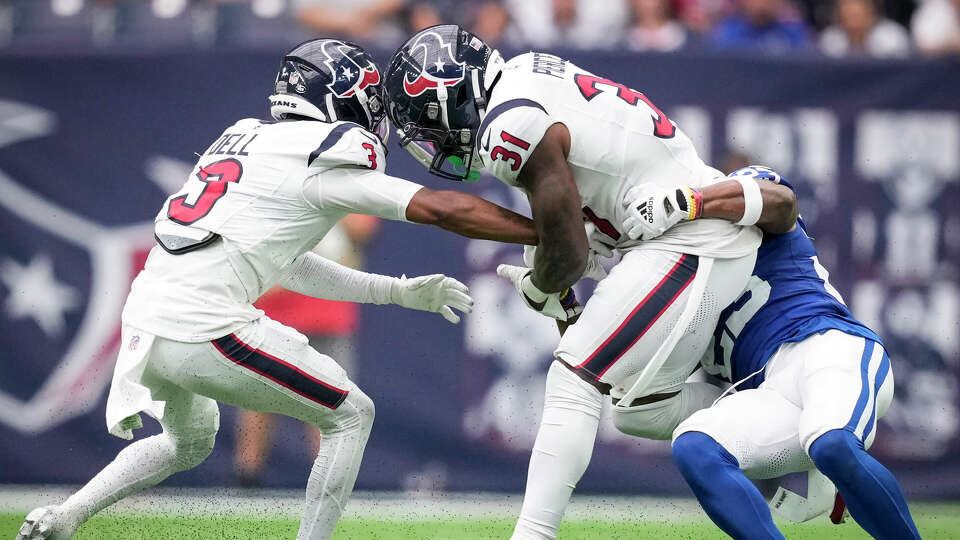 Houston Texans running back Dameon Pierce (31) is stopped for a loss by Indianapolis Colts cornerback Kenny Moore II (23) with Tank Dell reaching in for the ball during the second half an NFL football game Sunday, Sept. 17, 2023, in Houston.