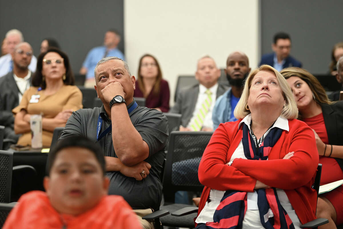 People watch a video screen displaying information about proposed school closures and consolidations during a San Antonio Independent School District Board meeting on Monday, Sept. 18, 2023.