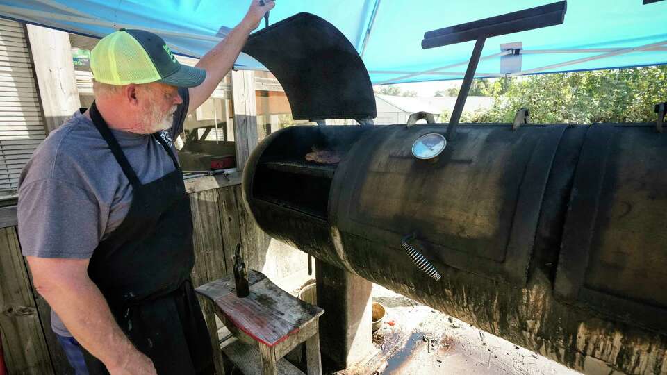 Phil Gessner checks on brisket he is smoking for brisket tacos at Gessner's Grub Bar-B-Que Tuesday, Sept. 19, 2023 in Spring. The old-school barbecue place is half food truck, half auto shop tucked away in an out-of-the-way location near The Woodlands.