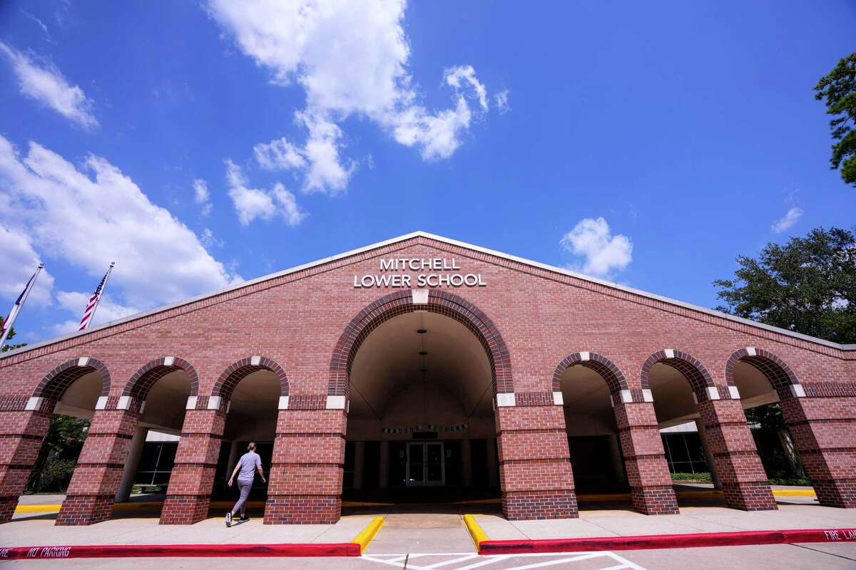 A woman walks toward the front entrance of the Mitchell Lower School at The John Cooper School on Tuesday, Sept. 19, 2023 in The Woodlands. As The Woodlands' John Cooper School begins its 35th school year, it is embarking on a 10-year strategic plan that includes a new athletic facility and visual arts center. The private school broke ground on the new athletic building in August.
