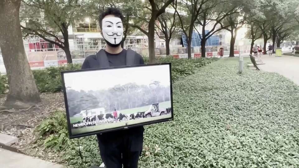 Anonymous for the Voiceless volunteer holding a sign at Discovery Green Park on July 23, 2022.