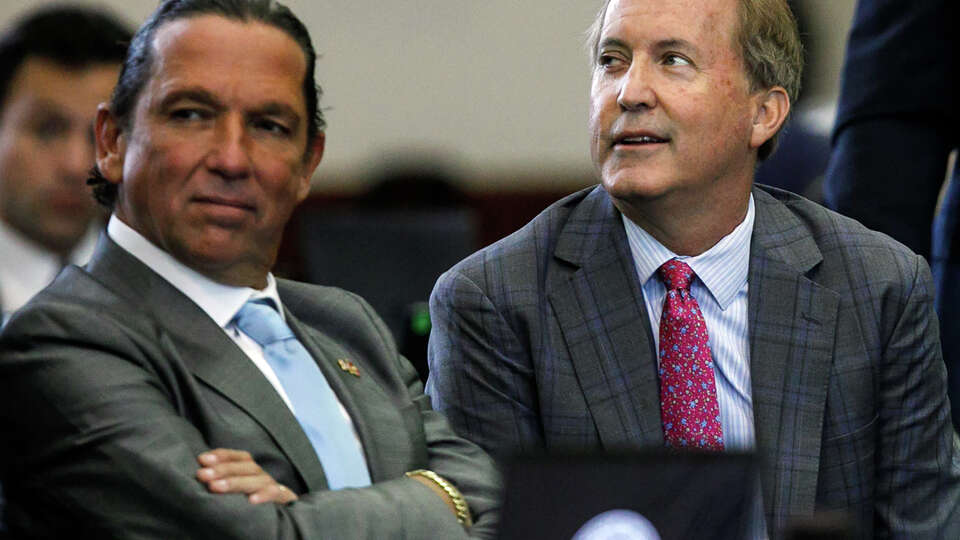 Texas Attorney General Ken Paxton, center, sits between defense attorneys Tony Buzbee, left, and Mitch Little, right, before starting the ninth day of his impeachment trial in the Senate Chamber at the Texas Capitol on Friday, Sept. 15, 2023, in Austin, Texas.