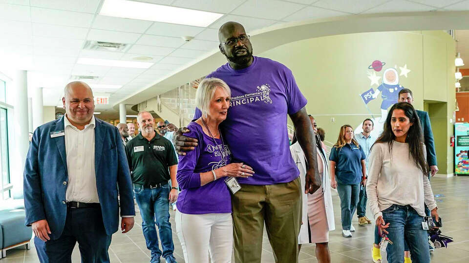 NBA legend, Shaquille O'Neal, partnered with MyEyeDr. gives Chris Winstead, the principal of Pine Shadows Elementary School, after he surprised kids in the auditorium on Friday, Sept. 22, 2023 in Houston.
