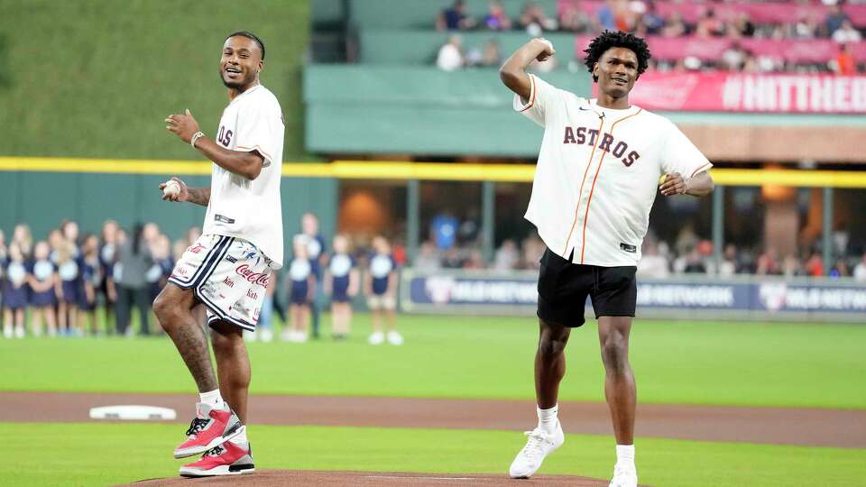 Houston Rockets' Cam Whitmore and Amen Thompson throw out the first pitch before the start of an MLB baseball game at Minute Maid Park on Friday, Sept. 22, 2023 in Houston.