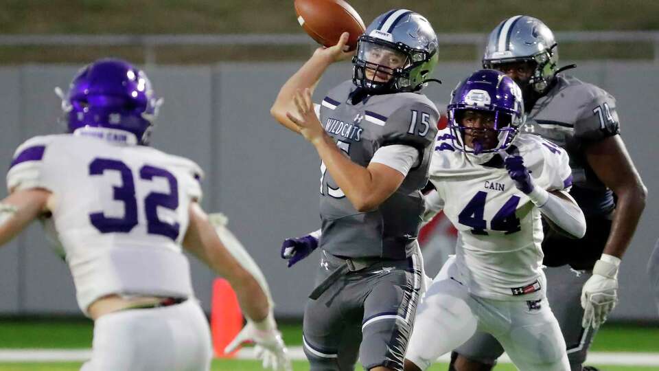 Tomball Memorial quarterback Aiden Martin (15) passes the ball between Klein Cain defenders Trent Lancaster (32) and Ray Chatham (44) during the first half of their District 15-6A high school football game held at Tomball ISD Stadium Friday, Sept. 22, 2023 in Tomball, TX.