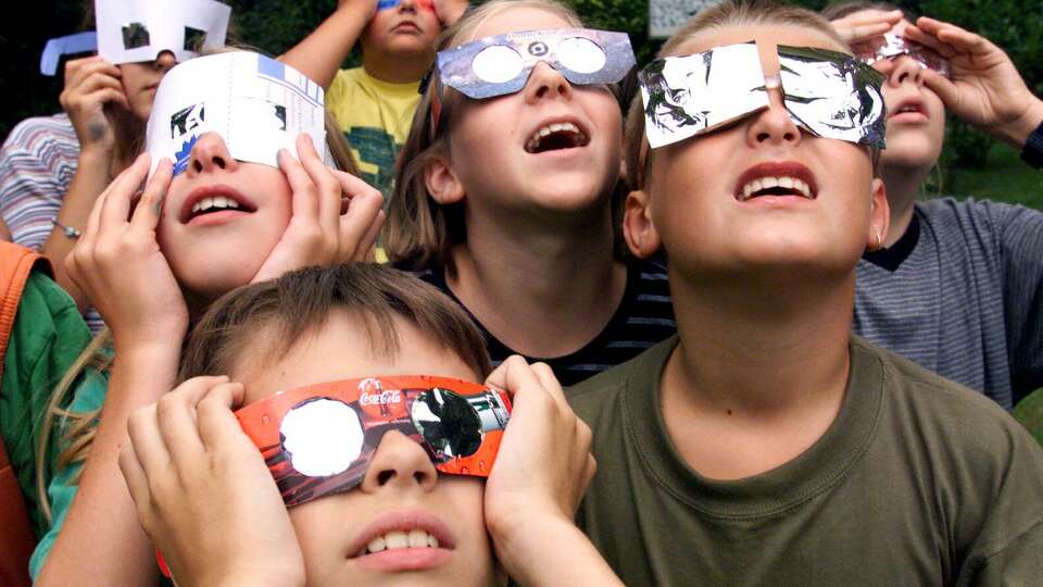 School children of a grammar school in Krefeld, Germany, watch the eclipse of the sun on Wednesday, August 11, 1999. The moon smothered the light of the sun Wednesday as the last total solar eclipse of the millennium swept across Europe toward the Bay of Bengal.