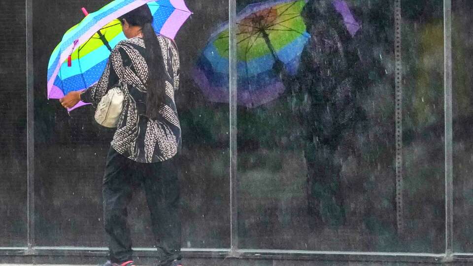 A pedestrian makes her way through a late afternoon rainstorm downtown on Monday, Sept. 25, 2023 in Houston.