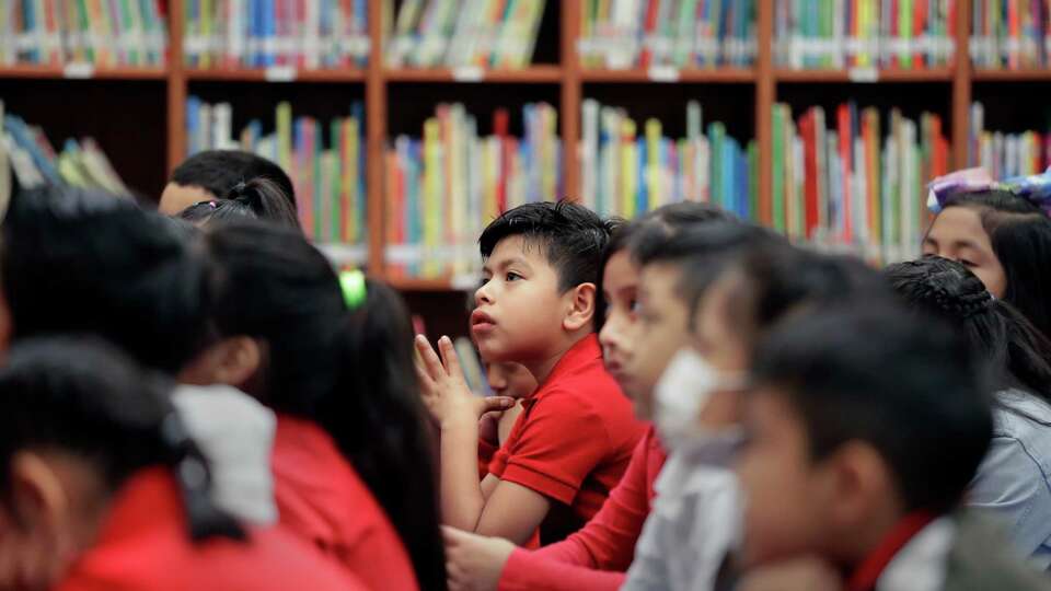 Second graders listen as a book is read by the librarian in the library at Pilgrim Academy, a K through 8th grade school, Thursday, Sept. 8, 2022 in Houston, TX.