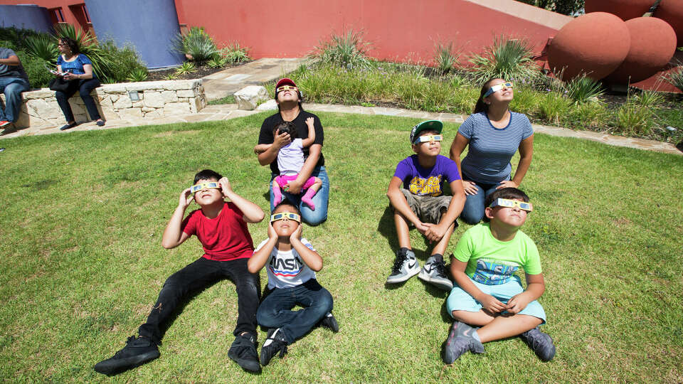 Central Library patrons watch the solar eclipse of 2017 while wearing safety eclipse glasses