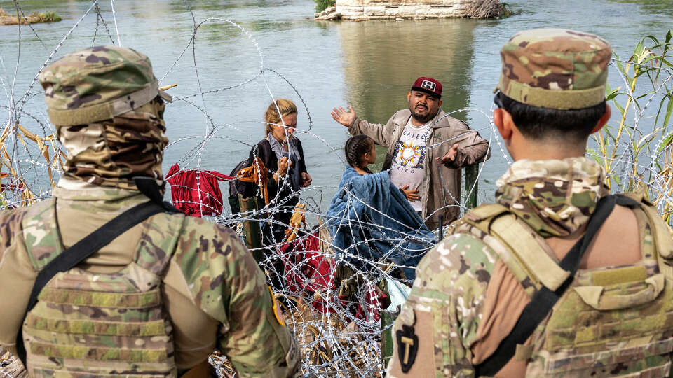 EAGLE PASS, TEXAS - SEPTEMBER 27: Venezuelan immigrant Louis Sanchez asks Texas National Guard troops to let his family pass through razor wire after they crossed the Rio Grande from Mexico on September 27, 2023 in Eagle Pass, Texas. A surge of migrants crossing the U.S. southern border seeking asylum has put pressure on U.S. immigration authorities, reaching record levels during the last week. (Photo by John Moore/Getty Images)