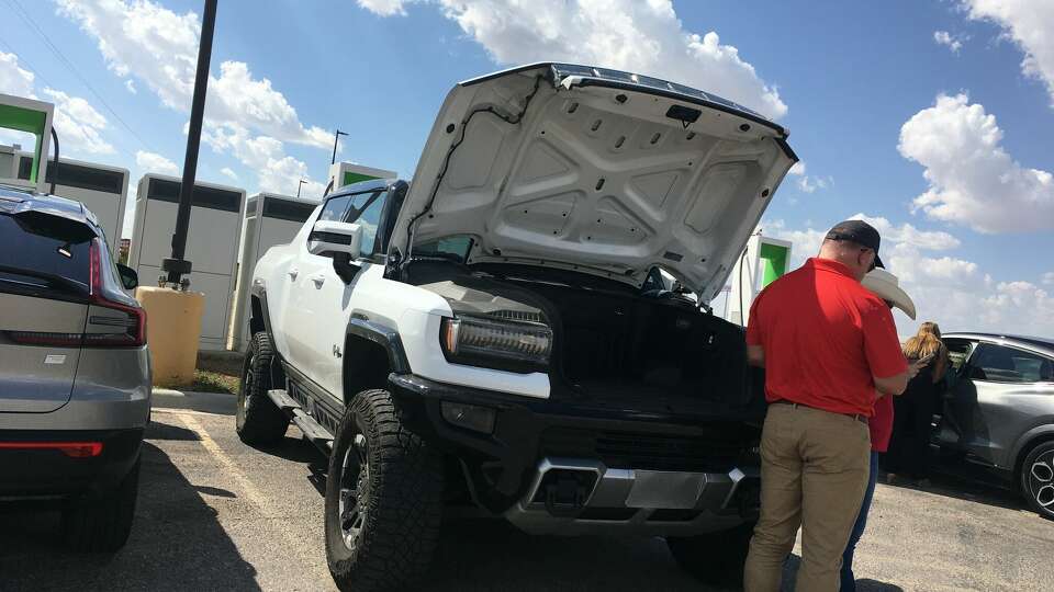 Matt Welch, state director, Conservative Texans for Energy Innovation, examines a Hummer Electric Vehicle during a caravan of electric vehicles through West Texas.