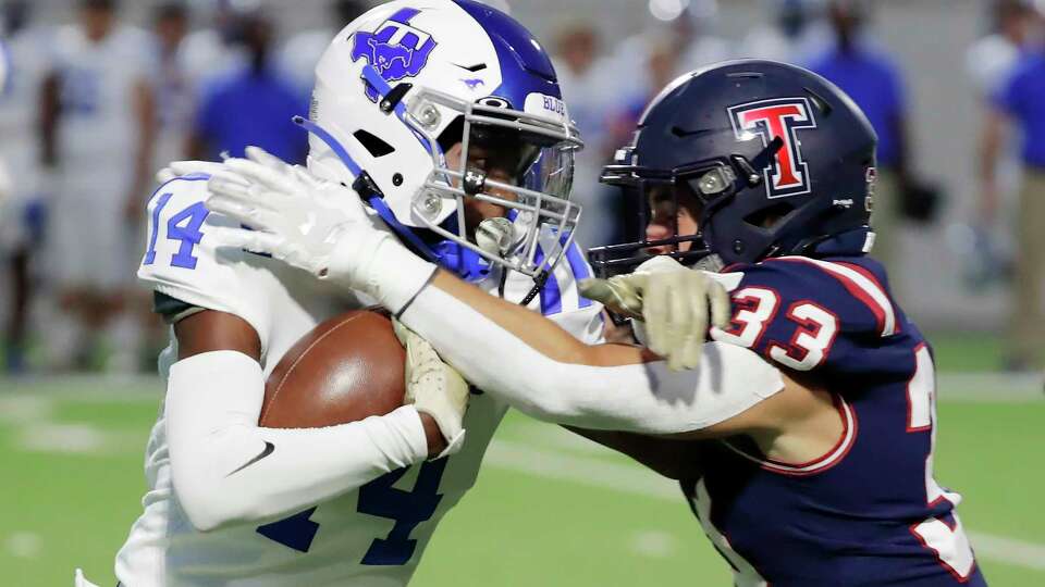 Katy Taylor wide receiver Cameron Lewis (14) is caught by Tompkins defensive back Nathaniel Chervenka (33) during the first half of their District 19-6A high school football game held at Legacy Stadium Thursday, Sept. 28, 2023 in Katy, TX.