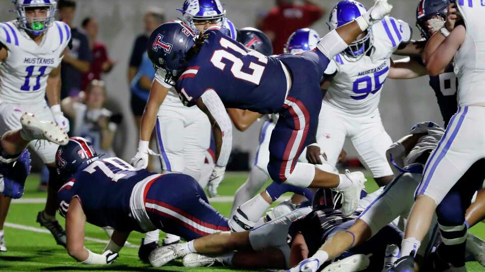 Tompkins running back Caleb Blocker (21) sails over the line to score a touchdown against Katy Taylor during the first half of their District 19-6A high school football game held at Legacy Stadium Thursday, Sept. 28, 2023 in Katy, TX.