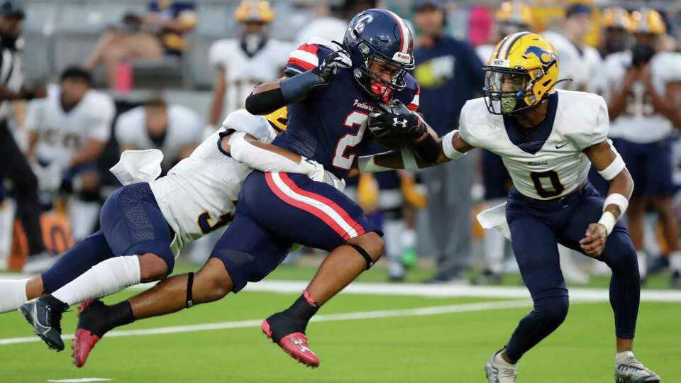 Cypress Springs running back Timothy Saunders (2) makes a gain between Cypress Ranch defenders Tristyn Davis, left, and Josiah Cooper, right, during the first half of their District 16-6A high school football game held at Cy-Fair FCU Stadium Friday, Sept. 29, 2023 in Cypress, TX.