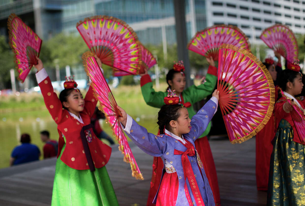 Young dancers perform a Korean fan dance dressed in hanbok during the Korean Festival Houston at the Discovery Green.