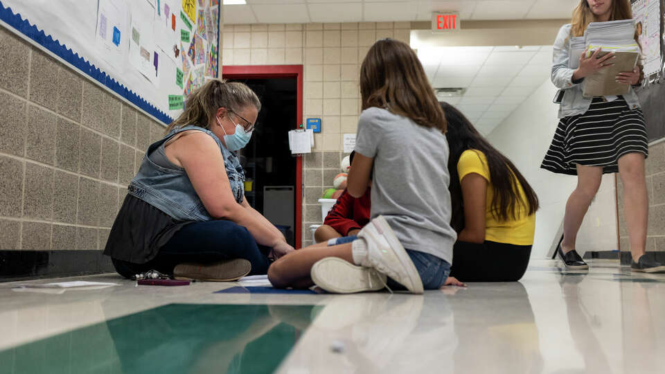 Special Education Teacher Heather Stubbs works with students in the hallway at Negly Elementary School in Kyle, Texas, on April 14, 2022. Negly is one of the most overcrowded schools in the district as Hays CISD grapples with its explosive growth.