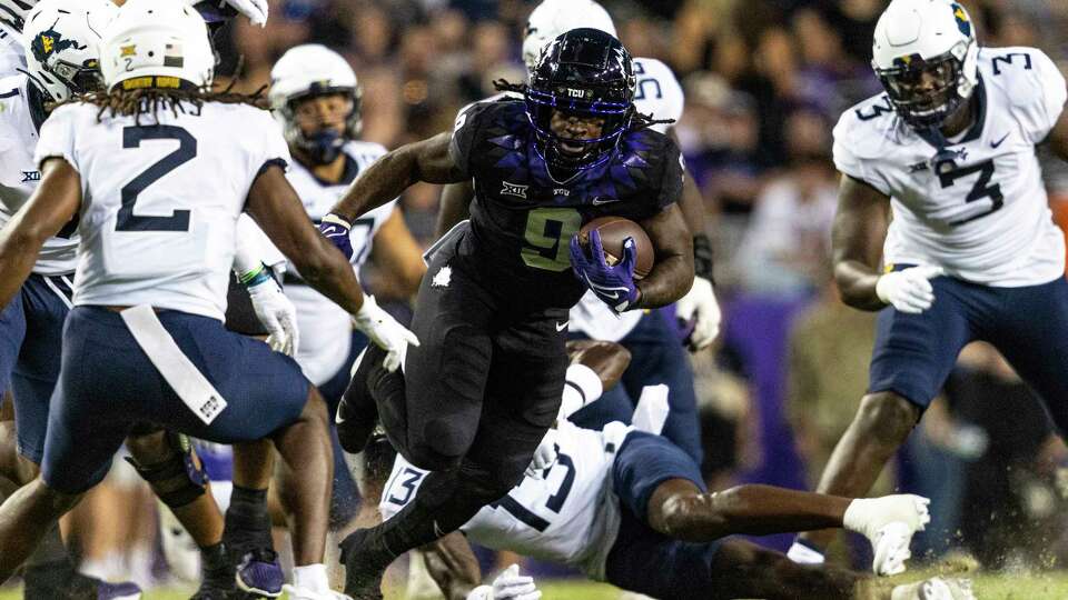 TCU running back Emani Bailey (9) evades West Virginia defenders during the first quarter of an NCAA college football game Saturday, Sept. 30, 2023, in Fort Worth, Texas. (Chris Torres