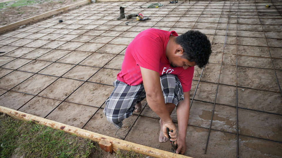 Henry Javier Guerra works on a home that belongs to his sister Tuesday, Oct. 3, 2023, in the Colony Ridge neighborhood in Liberty County.