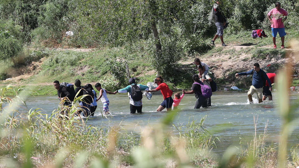 A group of migrants cross the Rio Grande at Eagle Pass, Texas, Thursday, Sept. 21, 2023. A surge of migrants started early in the week and continued through Thursday.