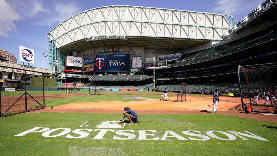 Sixto Zapata, a member of the Minute Maid Park grounds crew paints the MLB Postseason sign on the field during workouts in preparation for ALDS at Minute Maid Park on Friday, Oct. 6, 2023, in Houston.