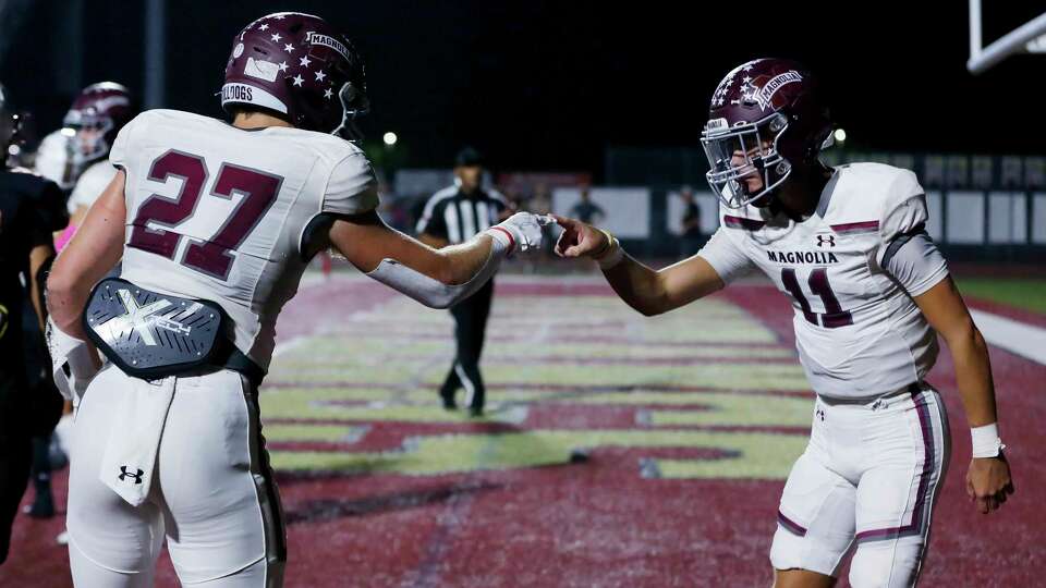 MagnoliaÕs Hunter Andrews (27) and Tanner Whittington (11) touch finger tips in celebration after the touchdown run by Andrews against Magnolia West during the first half of their District 10-5A high school football game held at Mustang Stadium Friday, Oct. 6, 2023 in Magnolia, TX.