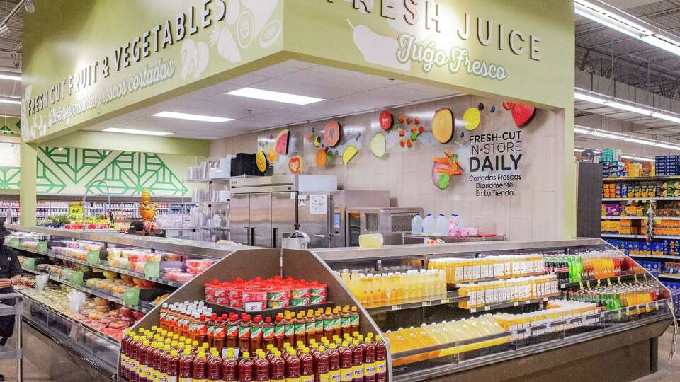 Spanish and English signs alert customers to the availability of aqua frescas, bottled fresh at the store, and catered to local customer requests and preferences, and a variety of fresh fruit bowls at the fruit and juice bar at Kroger, 11701 S. Sam Houston Pkwy. E., Friday, Oct. 6, 2023 in Houston.