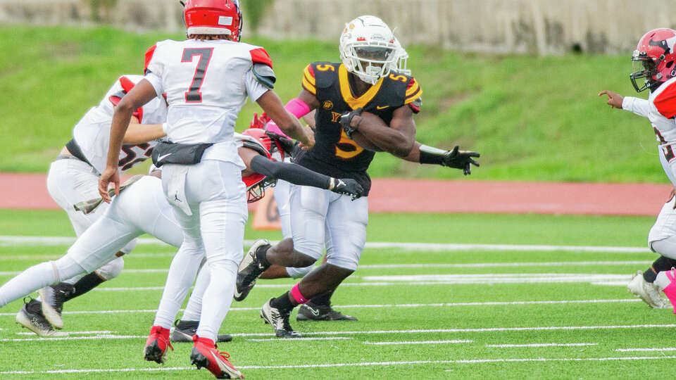 Yates' De'Shon Scott (5) fights the tackle of Furr's Berlon Francis (22) in the first half of a high school football game at Herman A. Barnett Stadium, Saturday, Oct. 7, 2023 in Houston.