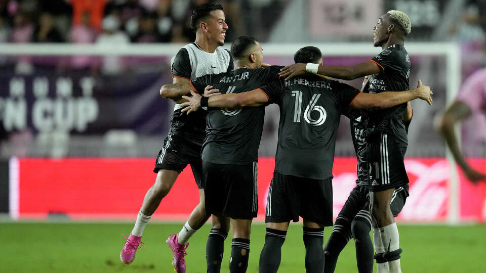 Houston Dynamo midfielder Amine Bassi (8), left, and forward Nelson Quinones (21), right, celebrate with teammates as they win their U.S. Open Cup final soccer match 2-1 over Inter Miami, Wednesday, Sept. 27, 2023, in Fort Lauderdale, Fla. (AP Photo/Rebecca Blackwell)