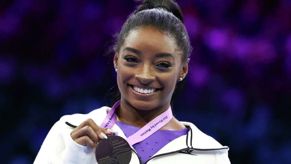 United States' Simone Biles shows her gold medal on the beam during the apparatus finals at the Artistic Gymnastics World Championships in Antwerp, Belgium, Sunday, Oct. 8, 2023.