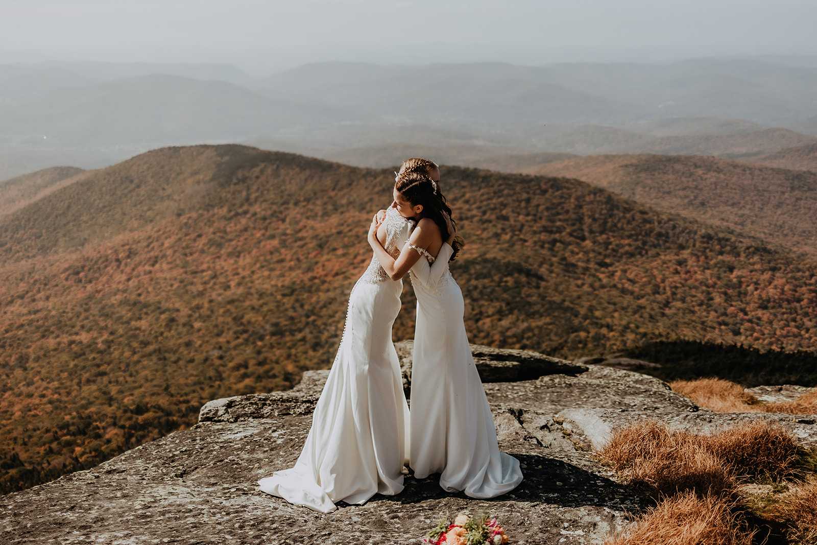 Couple hikes to top of mountain in wedding dresses to get married