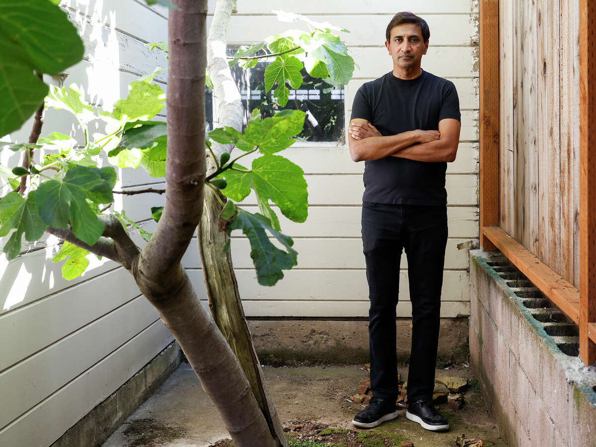 Hiten Madhani stands in the backyard of his home where he had hoped to renovate.