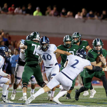 Reagan quarterback Brad Jackson (7) tries to get past Johnson's Walker Diharce (2) during the second half of their District 28-6A high school football game at Heroes Stadium on Friday, Oct. 13, 2023. Reagan beat Johnson 41-27.