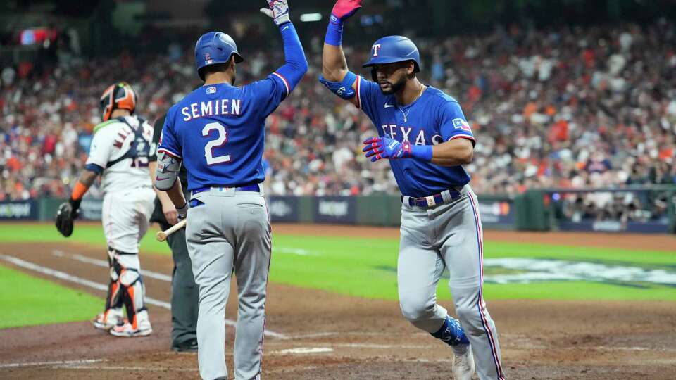 Texas Rangers Leody Taveras, right, gets a high-five from Marcus Semien after hitting a solo home run off Houston Astros starting pitcher Justin Verlander in the fifth inning of Game 1 during the American League Championship Series at Minute Maid Park on Sunday, Oct. 15, 2023, in Houston.