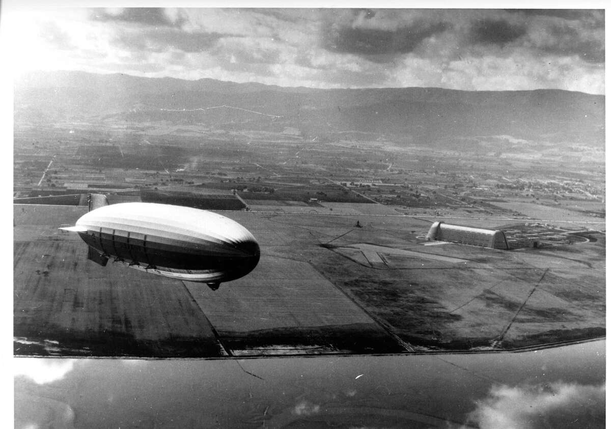 The Ames Aeronautical Laboratory at Moffett Field was established in 1939. It was home to test flights for cutting-edge aeronautics technology during World War II. Here, the Macon dirigible flies over the South Bay with Hangar One at Moffett Field in view on the right.