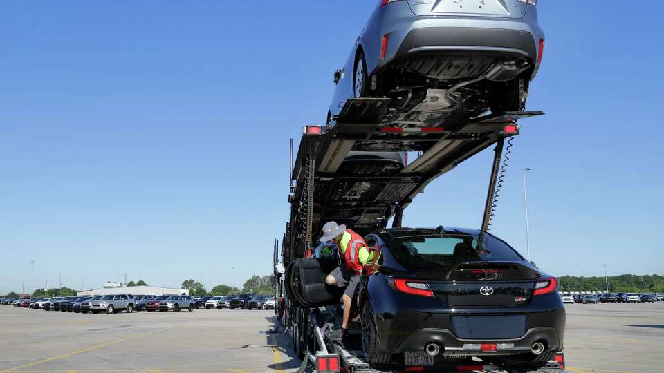 Justin Rodriguez, a driver with USAL, exits a car after driving it onto a trailer as he loads up various new Toyota vehicles to take to various dealerships at the Friedkin Group Gulf States Toyota processing facility Thursday, May 26, 2022 in Houston, TX.