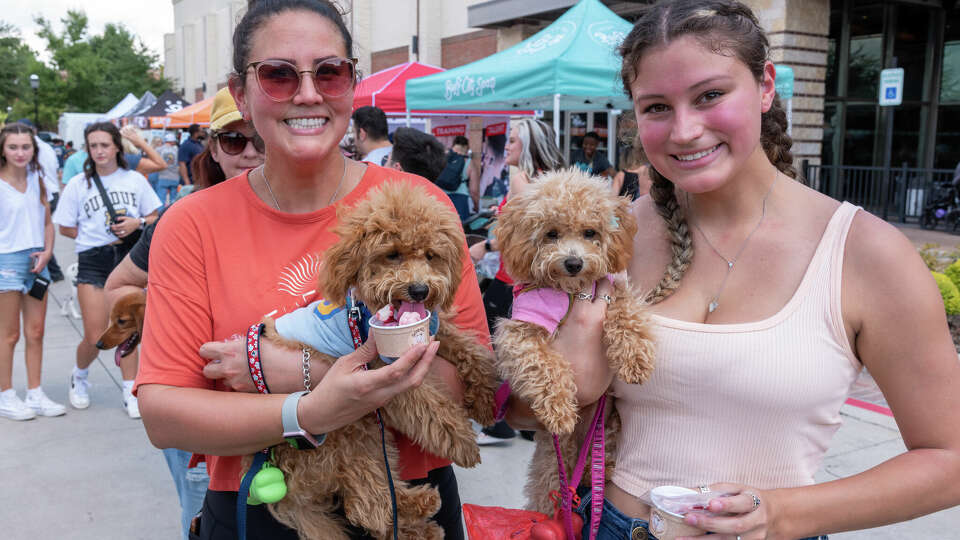 Visitors to the 2022 Paws Fest pose with their pups.