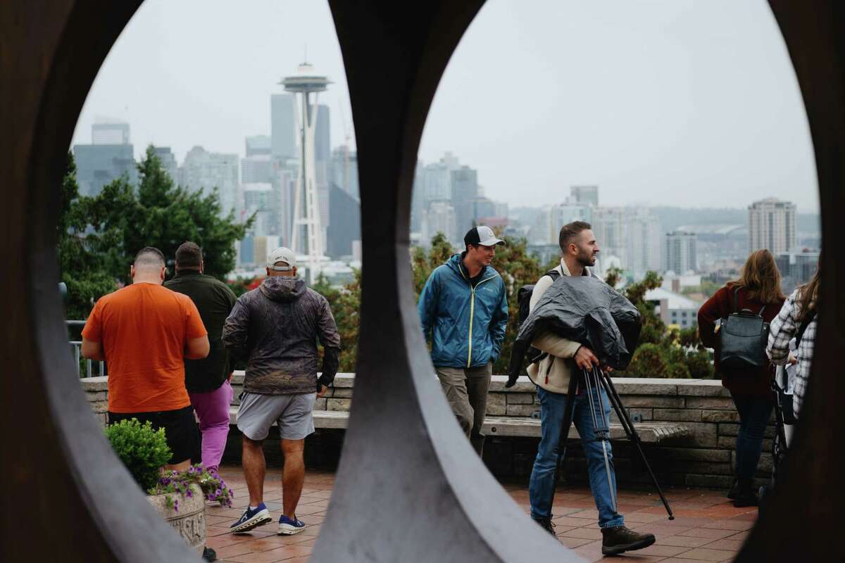 Even on a rainy day, a steady stream of tourists visit Kerry Park to checkout the skyline view of Seattle, Wash., on Oct. 9, 2023.