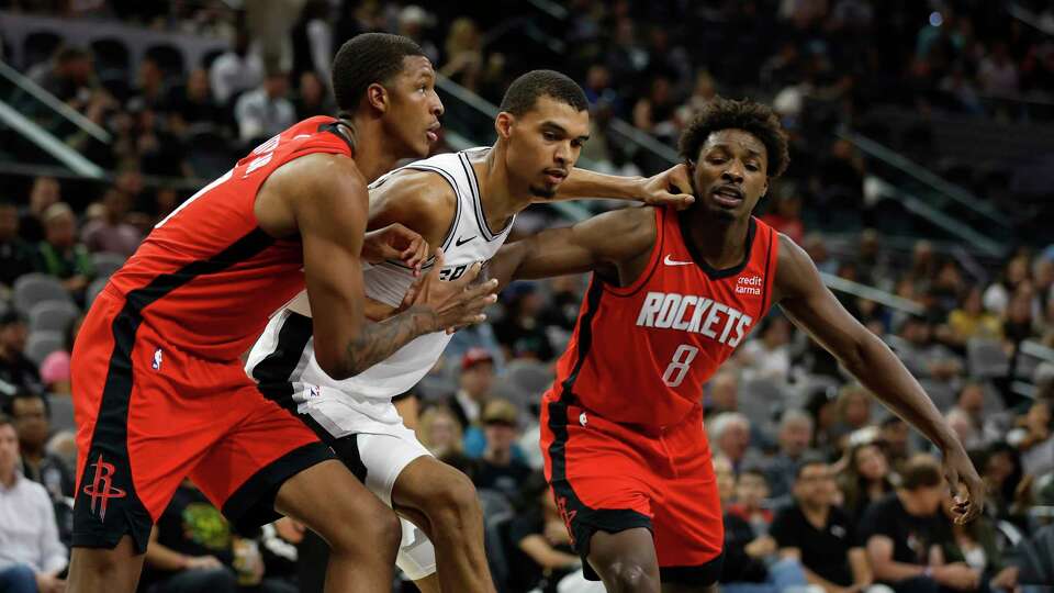 SAN ANTONIO, TX - OCTOBER 18: Victor Wembanyama #1 of the San Antonio Spurs battles for position against Jabari Smith #10 and Jae'Sean Tate #8 of the Houston Rockets in the first half of a pre-season NBA game at Frost Bank Center on October 16, 2023 in San Antonio, Texas. NOTE TO USER: User expressly acknowledges and agrees that, by downloading and or using this photograph, User is consenting to terms and conditions of the Getty Images License Agreement.