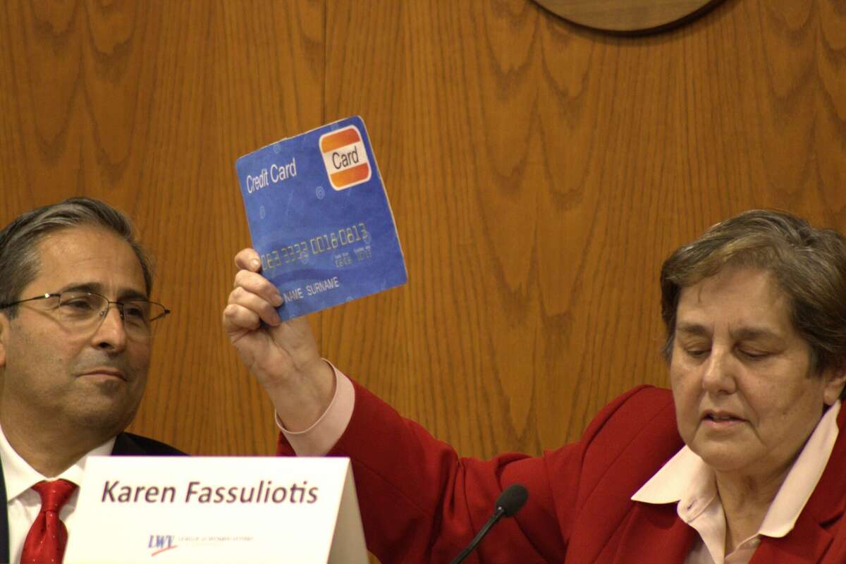Republican Karen Fassuliotis, right, holds up a credit card prop during a debate for Board of Estimate and Taxation candidates at Greenwich Time Hall on Oct. 18, 2023.