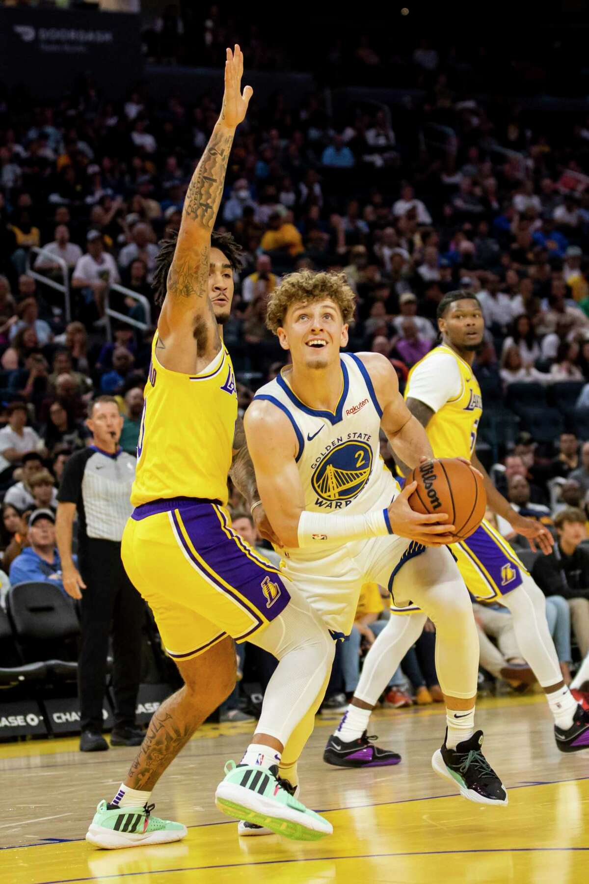 Golden State Warriors guard Brandin Podziemski drives against Los Angeles Lakers guard Jalen Hood-Schifino during the first quarter on Oct. 7 at Chase Center.