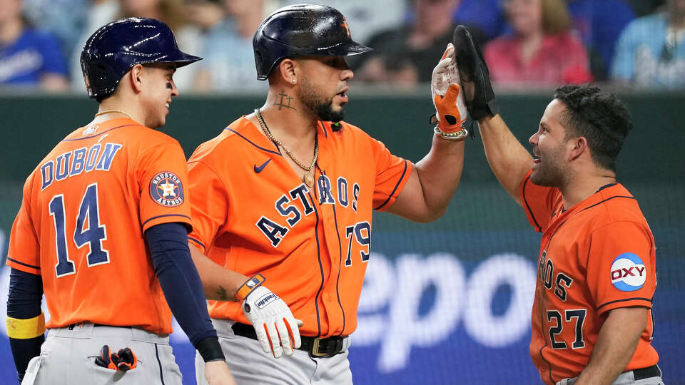 Houston Astros' Jose Altuve, right, gives Jose Abreu, center, a high-five after his two-run home run in the fourth inning of Game 4 of the American League Championship Series at Globe Life Field on Thursday, Oct. 19, 2023, in Arlington.