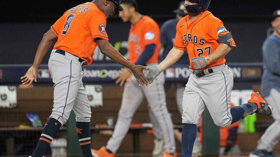 Houston Astros third base coach Gary Pettis, left, gives Jose Altuve a high-five after his three-run home run gave the team a 5-4 lead in the ninth inning of Game 5 during the American League Championship Series at Globe Life Field on Friday, Oct. 20, 2023, in Arlington.