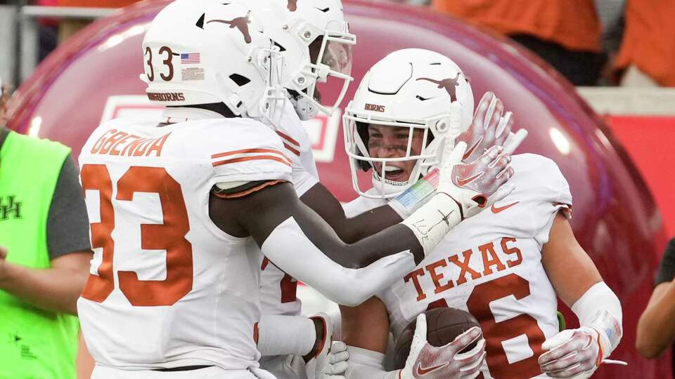 Texas Longhorns players celebrate after defensive back Michael Taaffe intercepted a pass by Houston Cougar quarterback Donovan Smith in the fourth quarter of an NCAA college football game at TDECU Stadium, Saturday, Oct. 21, 2023, in Houston.