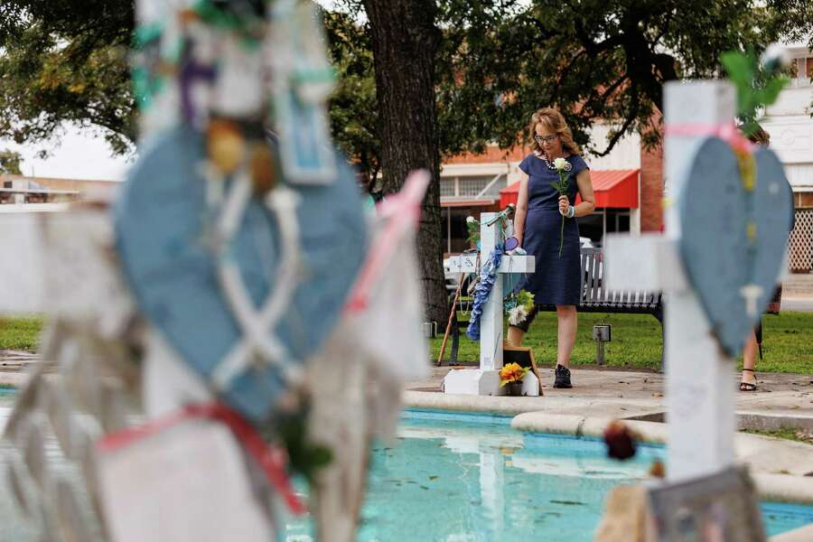 Former U.S. Congresswoman Gabrielle Giffords leaves flowers at the makeshift memorial crosses set up for the 21 Robb Elementary shooting victims on Monday, Oct. 23, 2023, at the town square in Uvalde, Texas. Giffords and members of her gun violence prevention organization GIFFORDS visited Uvalde for the first time to meet with community leaders, families who lost loved ones and to pay their respects to the 21 people killed on May 24, 2022. In 2011, Giffords and 18 others were shot in a supermarket parking lot in Arizona during one of her constituent meetings. Thirteen people, including Giffords, were injured and six people were killed.