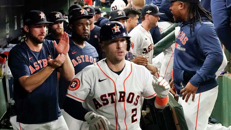 Houston Astros Alex Bregman, center, celebrates in the dugout after hitting solo home run off Texas Rangers starting pitcher Max Scherzer in the third inning during Game 7 of the American League Championship Series at Minute Maid Park on Monday, Oct. 23, 2023, in Houston.