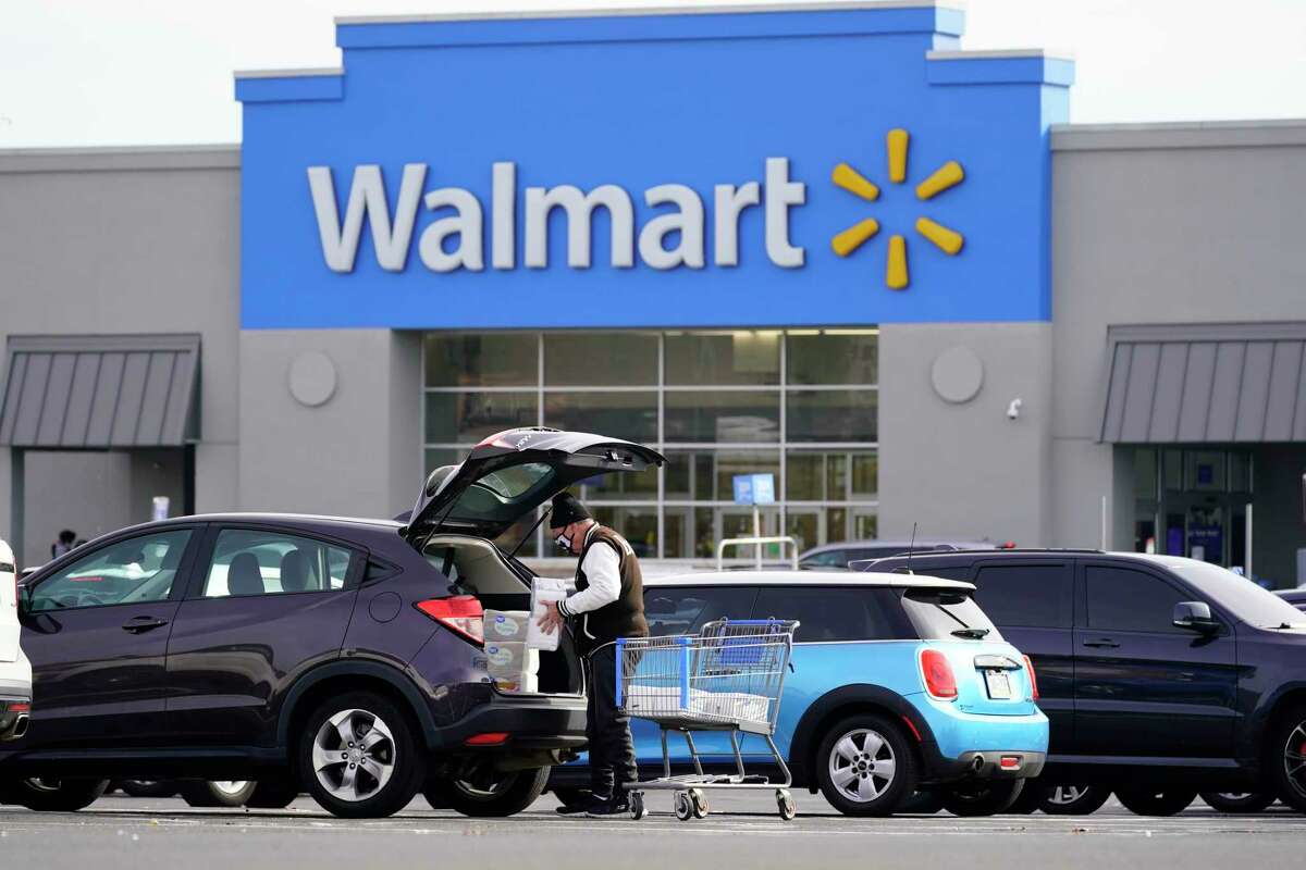 FILE - A customer loads his car after shopping at Walmart in Philadelphia, Nov. 17, 2021. Next month, Walmart, the nation's largest private employer, will expand health insurance coverage nationwide for employees who request the services of a doula. A person trained to assist pregnant women.