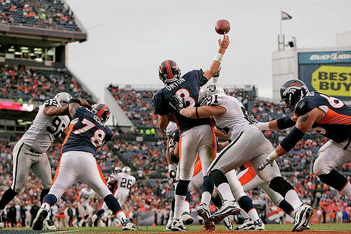 DENVER - OCTOBER 24: Quarterback Kyle Orton #8 of the Denver Broncos is hit as he makes a pass from his own end zone by defensive end Trevor Scott #91 of the Oakland Raiders at INVESCO Field at Mile High on October 24, 2010 in Denver, Colorado. The Raiders defeated the Broncos 59-14. (Photo by Justin Edmonds/Getty Images) *** Local Caption *** Kyle Orton;Trevor Scott