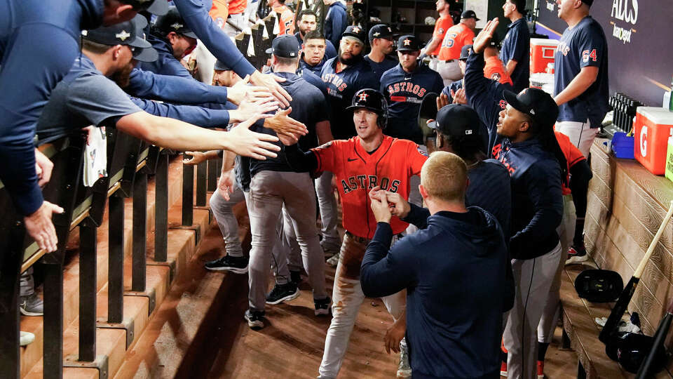 Houston Astros players celebrate with Alex Bregman after scoring on designated hitter Yordan Alvarez's RBI single in the first inning during Game 4 of the American League Championship Series at Globe Life Field on Thursday, Oct. 19, 2023, in Arlington. Bregman hit an 2-RBI triple early in the inning.