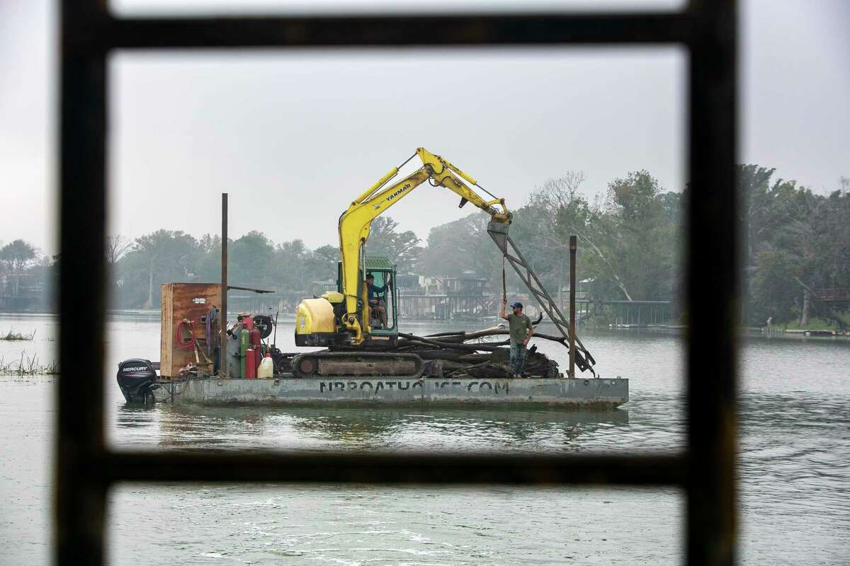 A pile of logs sit atop Chip Bryant’s barge during a lake cleanup day on Lake Dunlap on Nov. 4. The logs and other debris were pulled from the lake, which has been refilled recently after a dam failure in 2019 caused it to drain. 