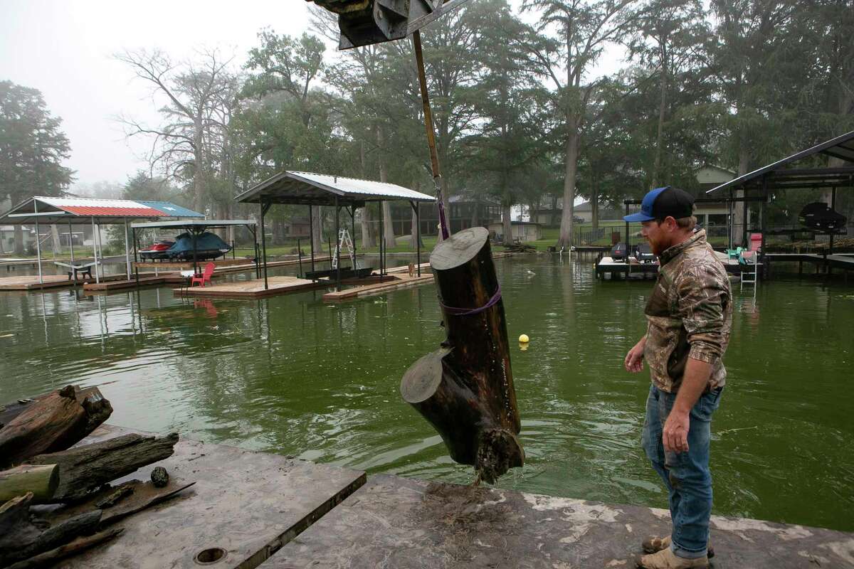 Chris Cambron and Chip Bryant lift a log out of Lake Dunlap on Nov. 4.